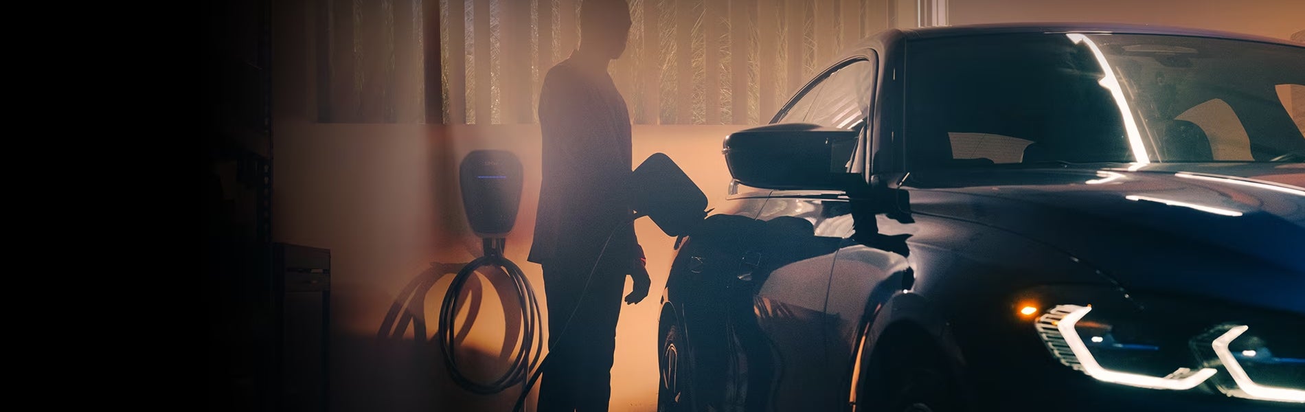 Shadow of a man charging a black BMW Electric Vehicle.